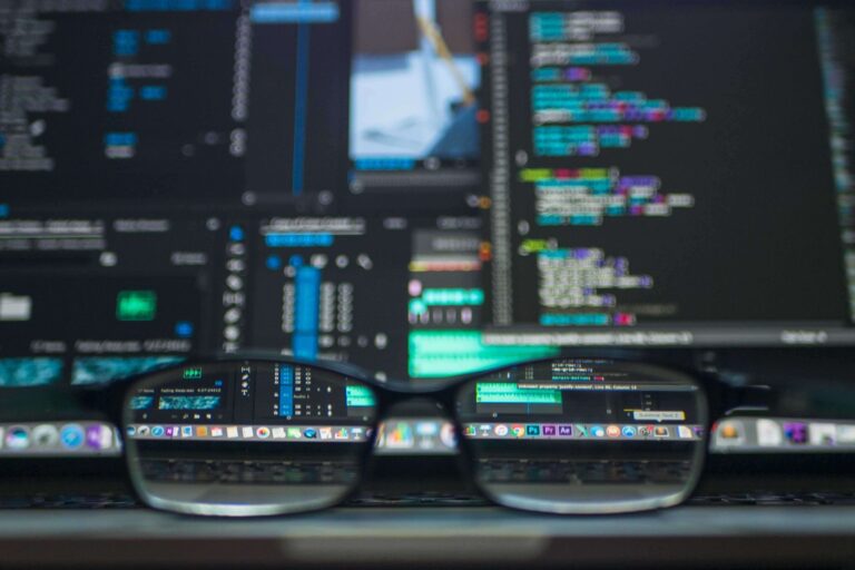 close up photo of eyeglasses in front of a monitor