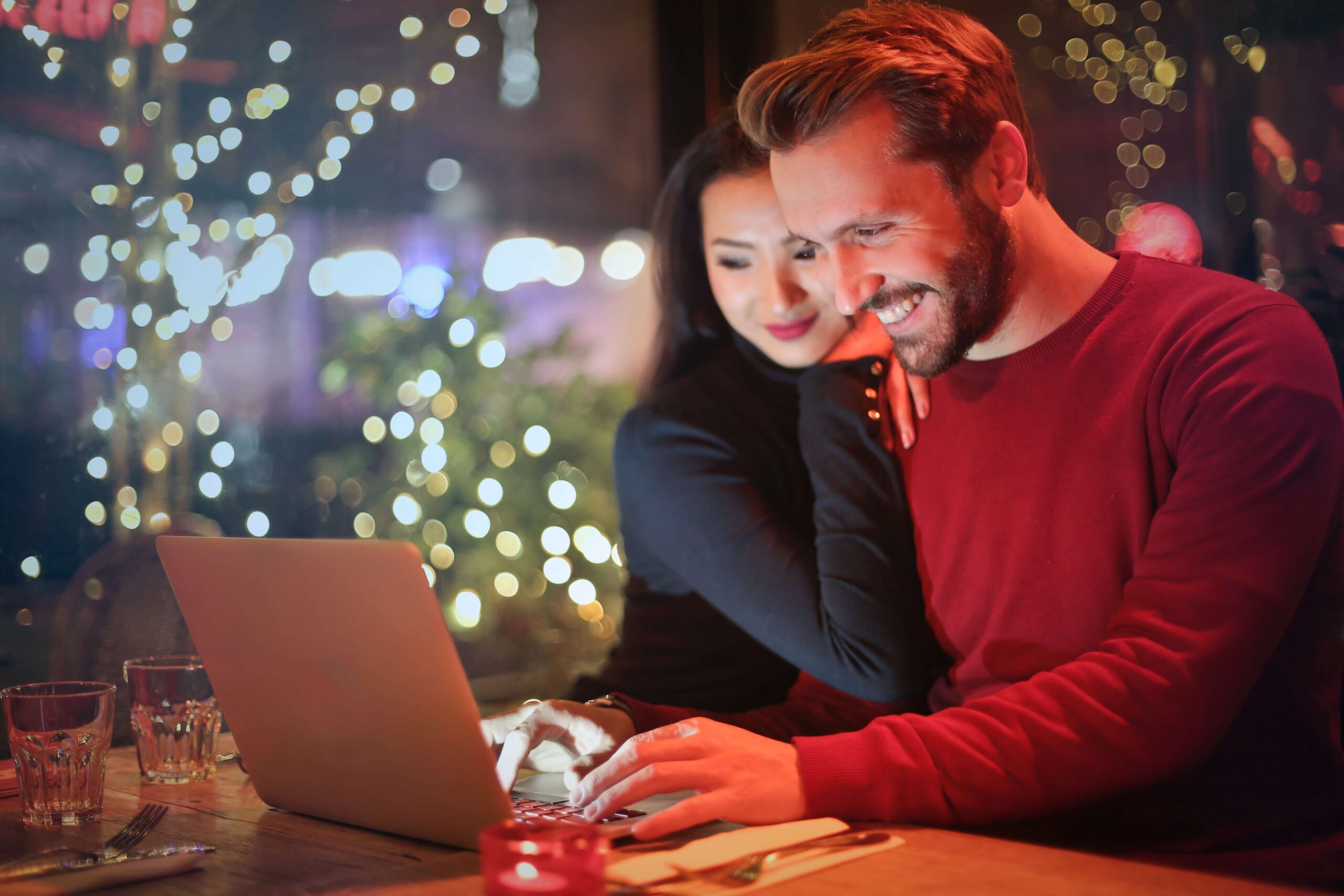 man and a woman looking at a laptop A man and a woman looking at a laptop on Christmas